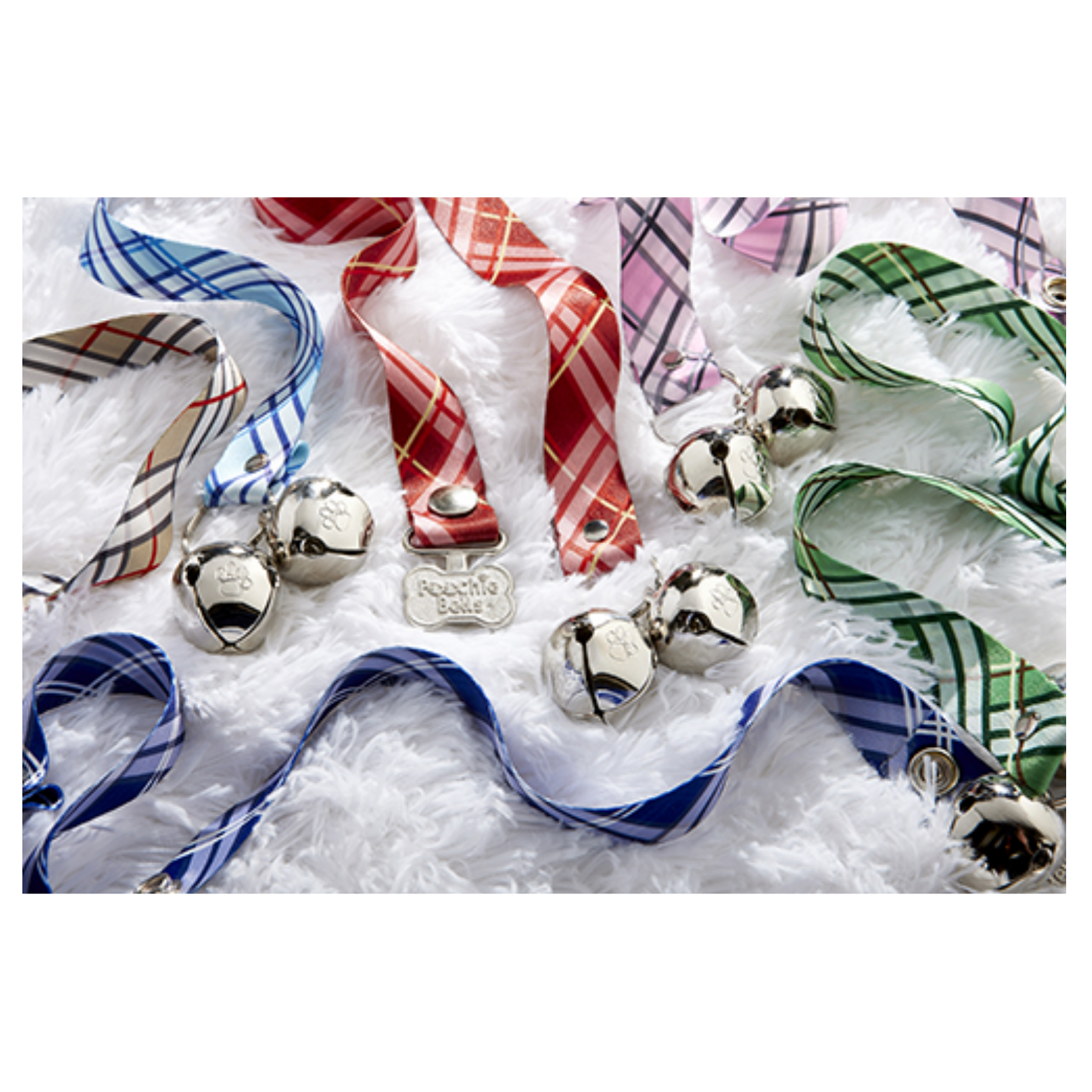 Assorted PoochieBells dog doorbell straps with plaid patterns in blue, red, green, pink, and beige, arranged on a white textured surface. Each strap includes shiny metal jingle bells and a small silver bone-shaped PoochieBells tag.