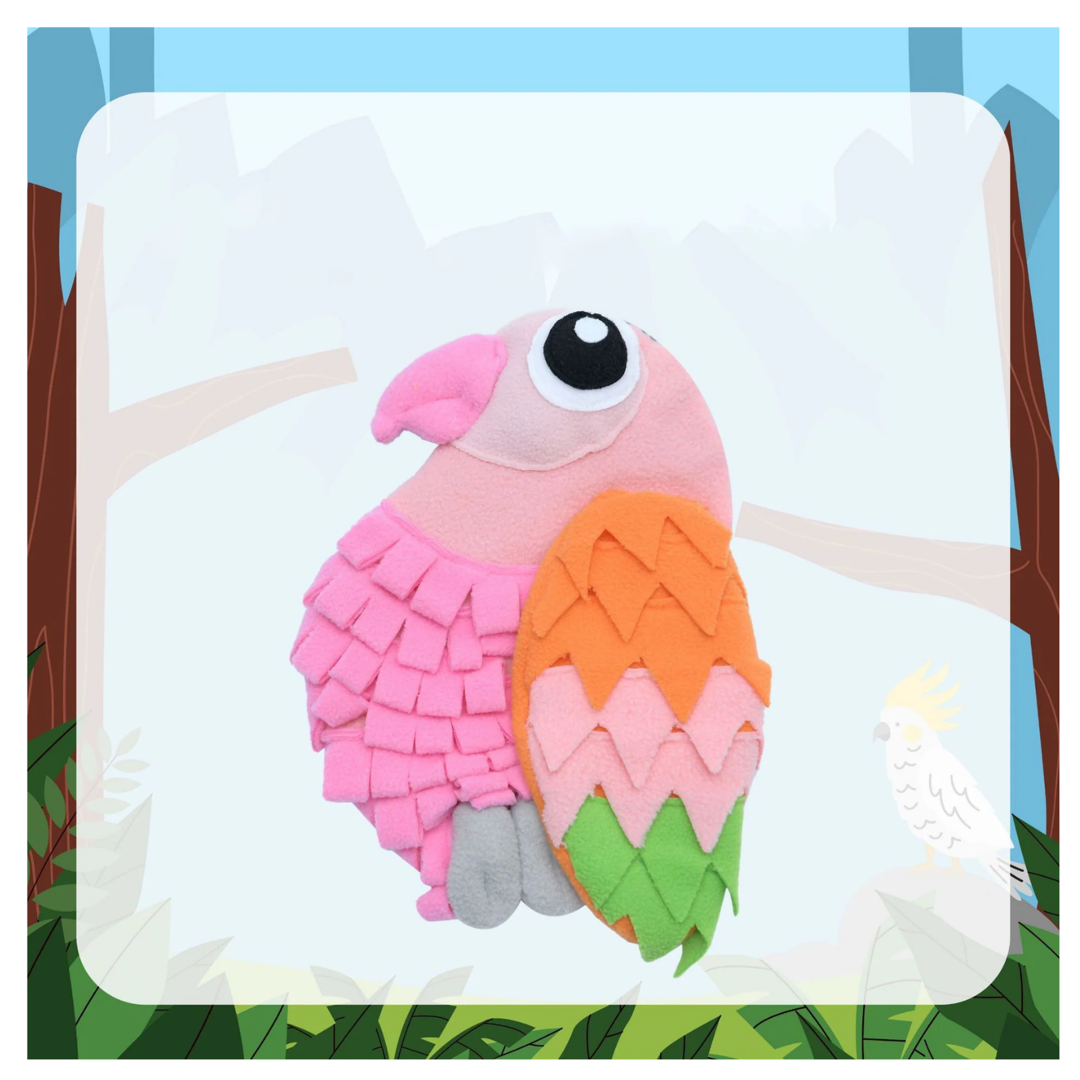 Pink parrot-shaped snuffle feeding mat for dogs and cats made of soft fleece layers, featuring a large cartoon eye, pink body, orange and green layered wing feathers, and gray feet, displayed against a jungle-themed background.