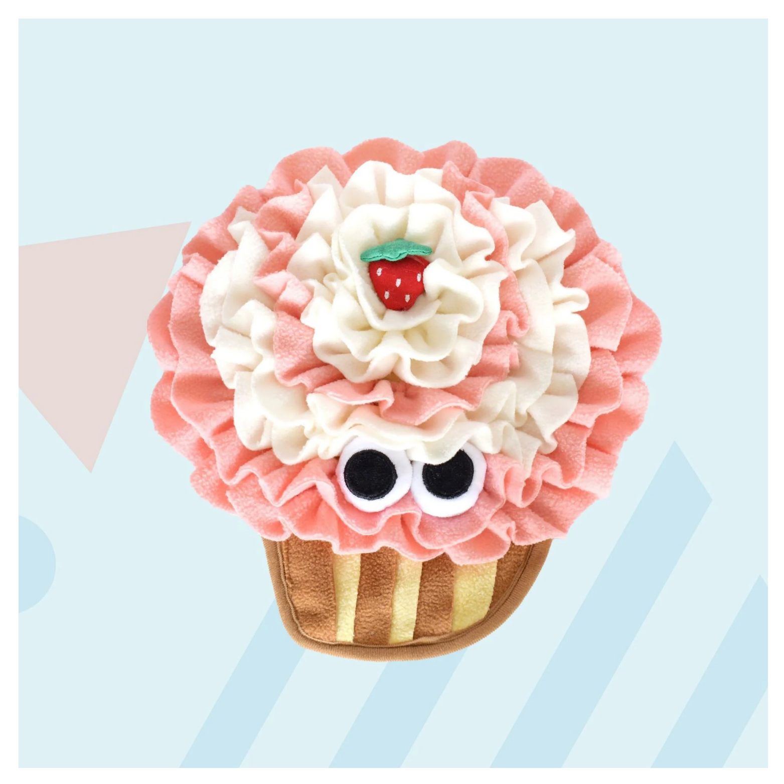 Cupcake-shaped snuffle feeding mat for dogs and cats with layered pink and cream fleece “frosting,” a small plush strawberry on top, large cartoon eyes on the front, and a tan and yellow striped cupcake base, displayed on a pastel background.