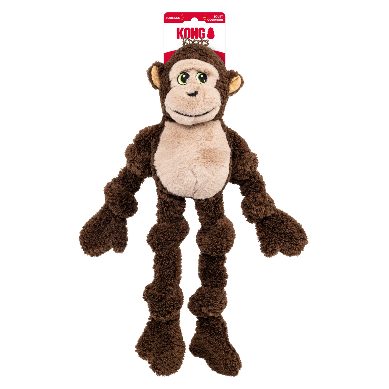 Plush brown monkey dog toy with long dangling arms and legs, beige face and belly, green embroidered eyes, and a stitched smile, shown hanging from a KONG retail tag against a black background.