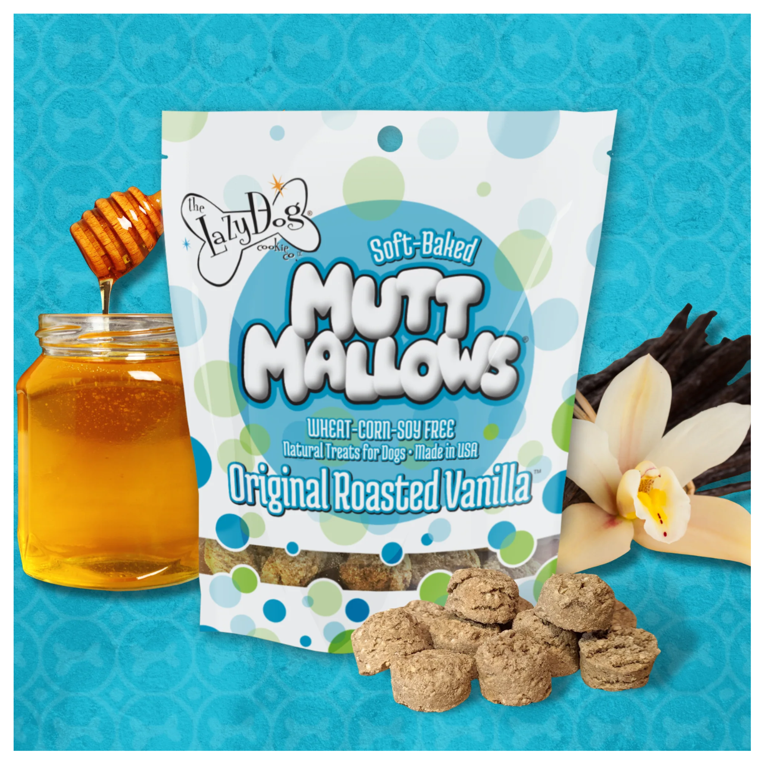 A bag of The Lazy Dog Cookie Company Soft-Baked Mutt Mallows, Original Roasted Vanilla flavor, displayed on a blue background with a jar of honey, vanilla flowers, and several beige, round dog treats in front.
