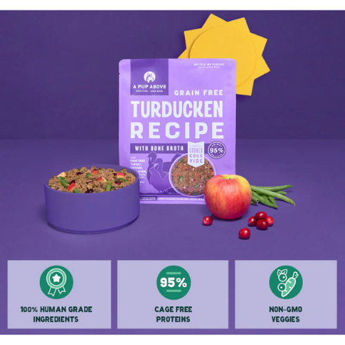 Bag of A Pup Above Grain Free Turducken Recipe dog food displayed with a bowl of the food, an apple, green beans, and cranberries, with icons below highlighting 100% human-grade ingredients, 95% cage-free proteins, and non-GMO veggies.