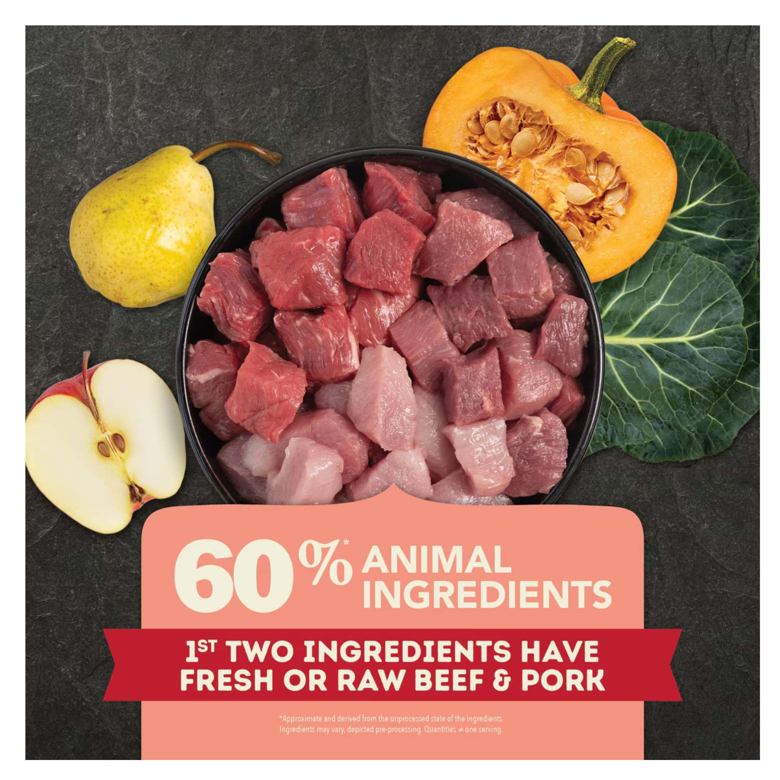 Bowl filled with raw cubed beef and pork surrounded by a pear, sliced apple, pumpkin half, and leafy greens on a dark background, with overlaid text reading “60% animal ingredients” and “1st two ingredients have fresh or raw beef & pork.”