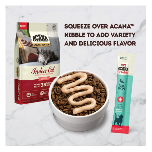 Bowl of dry cat kibble topped with a creamy tuna purée squeezed in a zigzag pattern, shown next to ACANA Indoor Cat dry food and an ACANA Lickables Tuna Recipe sachet, demonstrating use as a kibble topper.