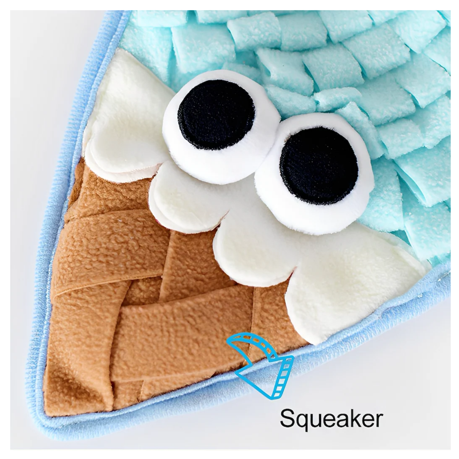 Close-up of the lower section of the ice-cream snuffle mat showing the cone pattern and large plush eyes, with an arrow pointing to the bottom labeled “Squeaker,” indicating a built-in squeaky feature.
